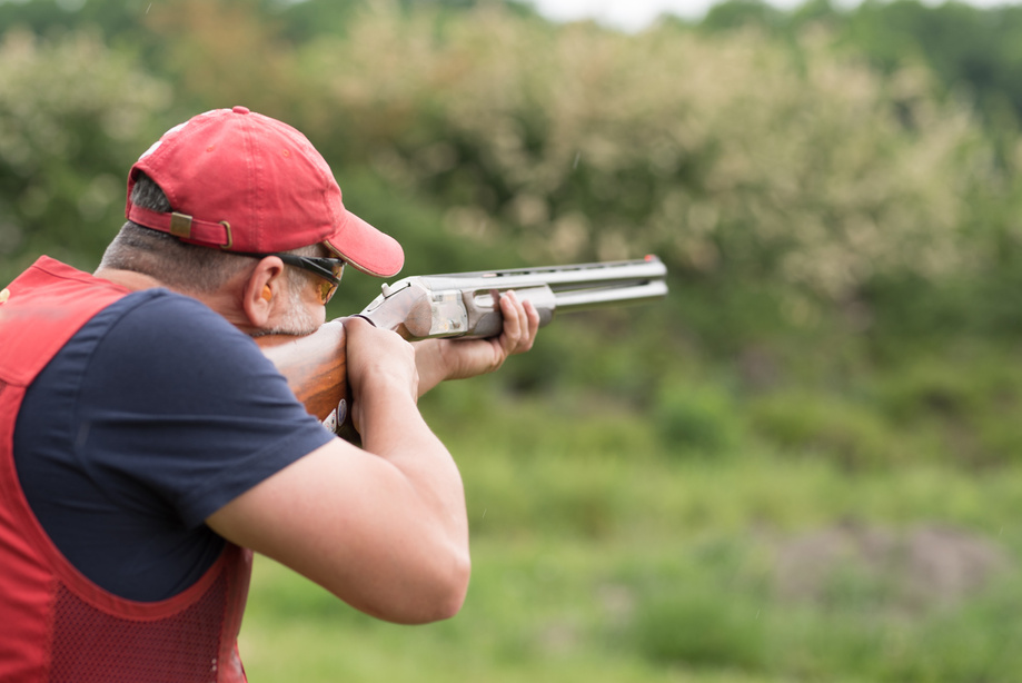 Man shooting skeet with a shotgun. Skeet shooting, trap shooting.
