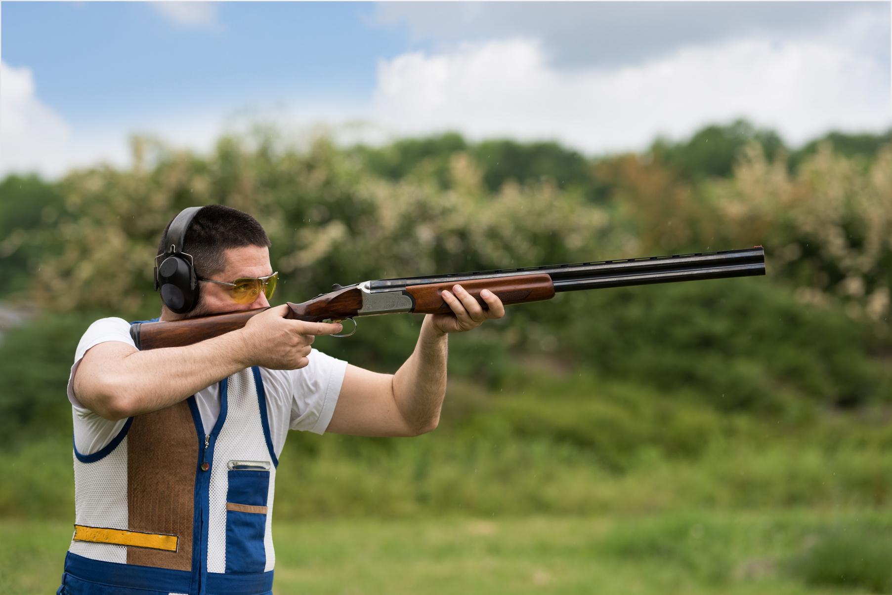 Man shooting skeet with a shotgun. Skeet shooting, trap shooting.